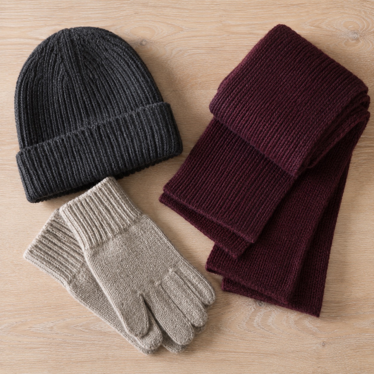 Knitted beanie, scarf and wool gloves arranged together